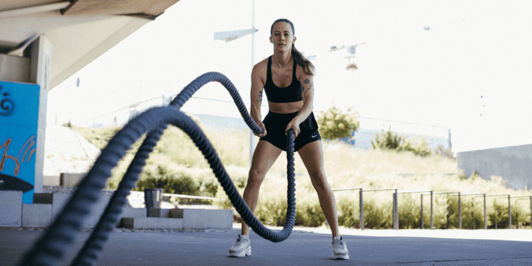 Kobieta trenuje z battle ropes